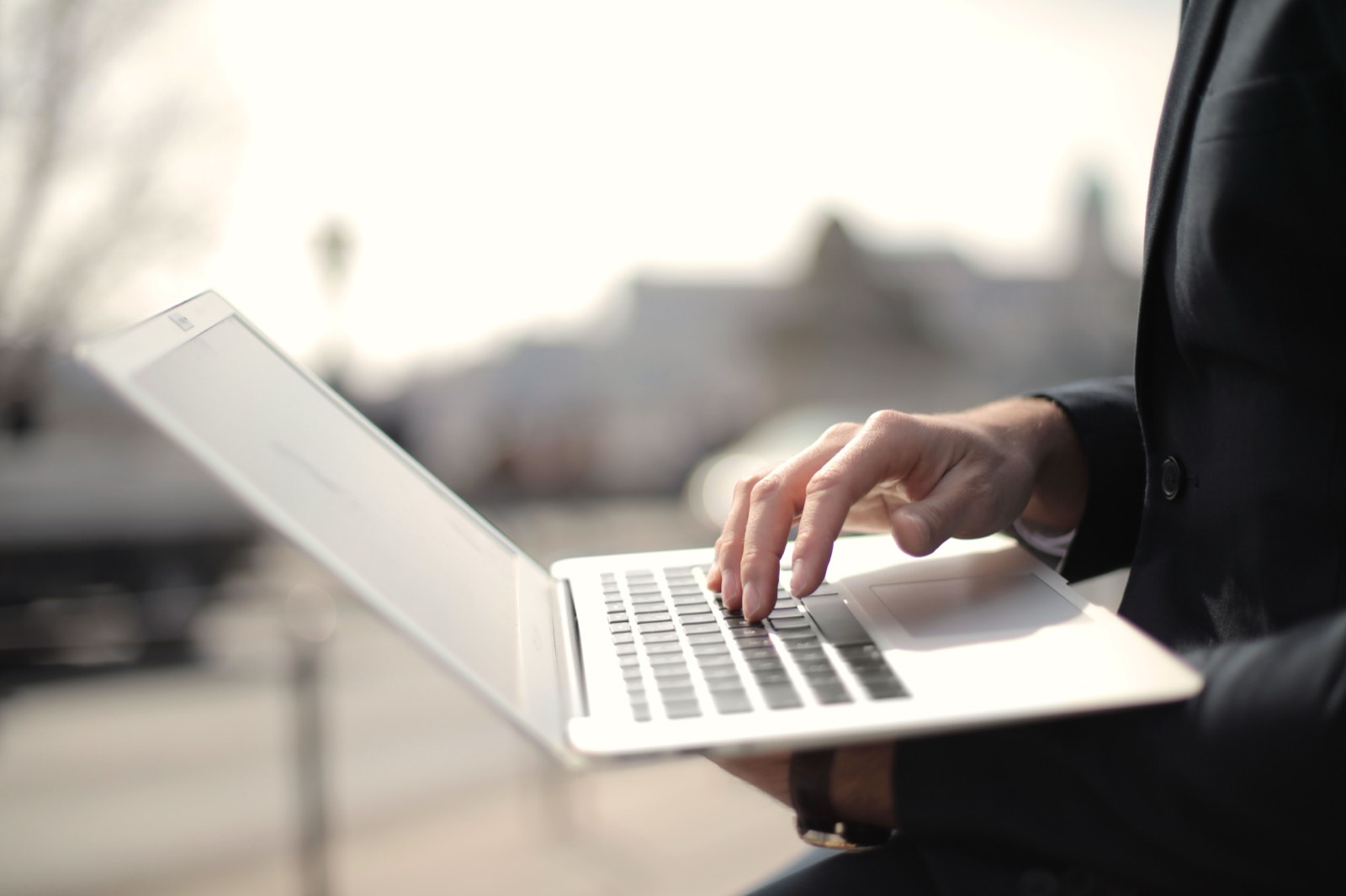 Person working on a laptop beside a bright window