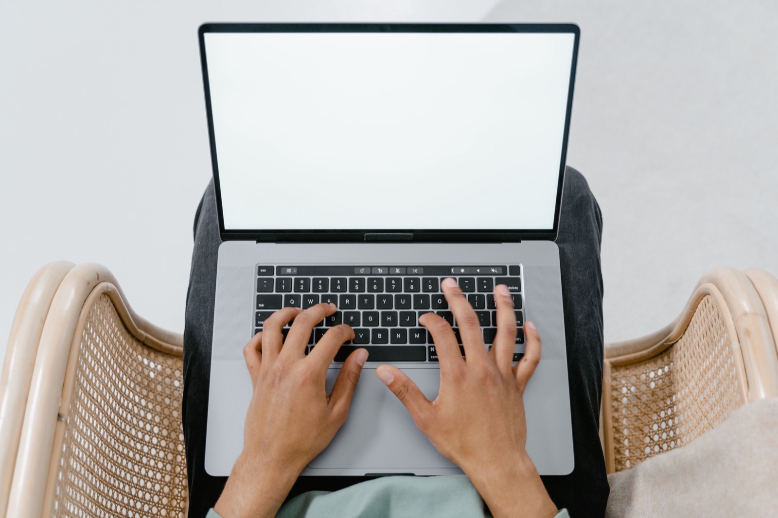 Hands typing on a laptop at a wooden table